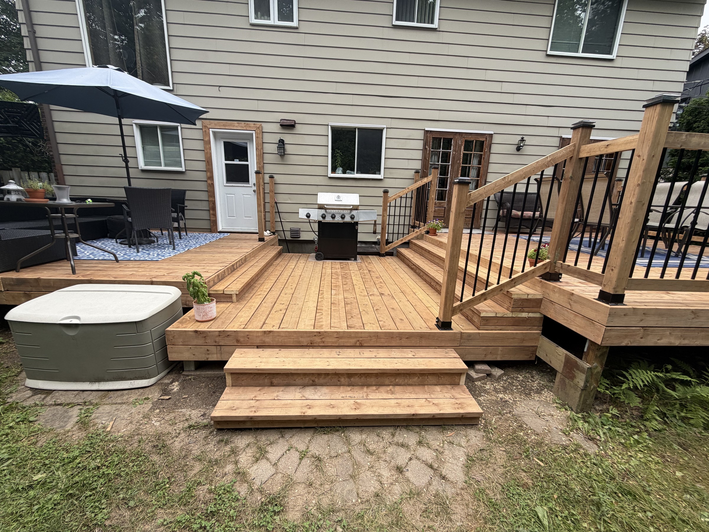 Terrasse en bois avec marches, à l’arrière d’une maison