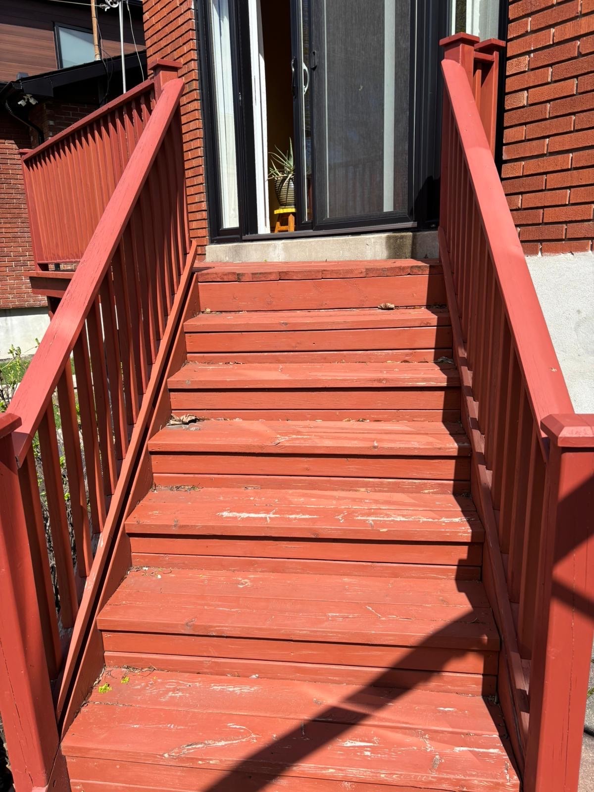 Escalier extérieur en bois rouge à la peinture usée et écaillée